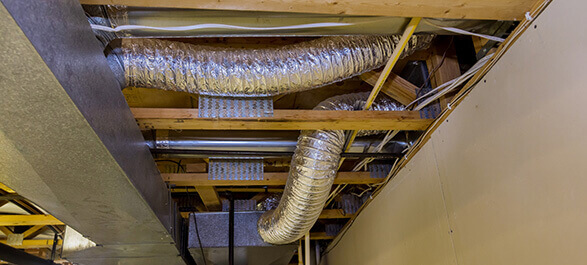 An image showcasing ductwork in the ceiling, an essential part of heating and cooling systems, which helps with proper air circulation. It highlights the integration of ductwork in maintaining efficient AC repair, furnace repair, and boiler repair systems. Proper ductwork ensures that the heating and cooling system runs efficiently, improving the overall energy performance and indoor air quality while minimizing the need for costly repairs and maintenance.