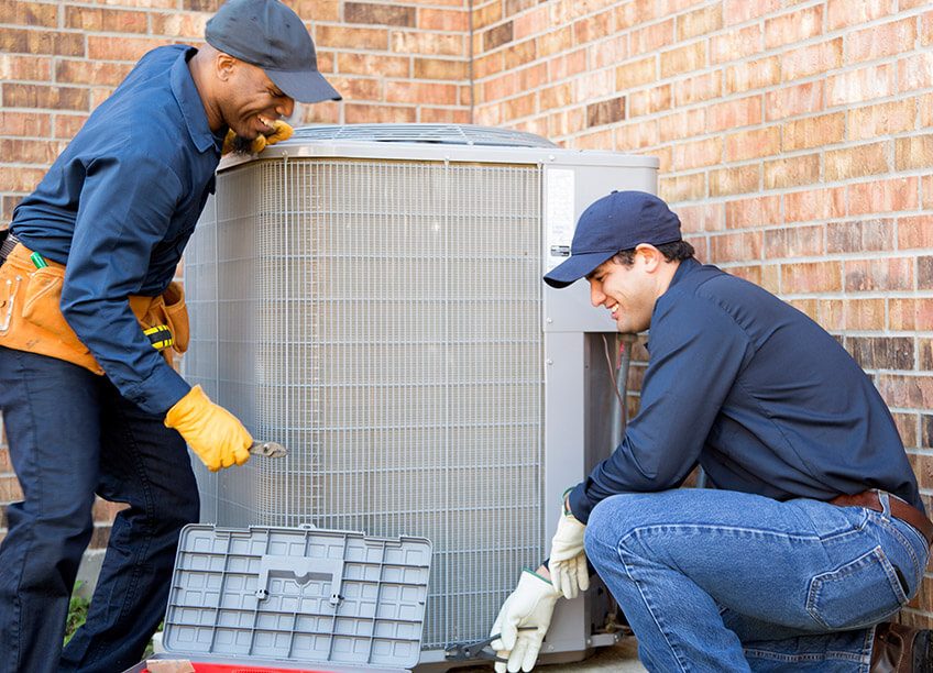 A pair of outdoor AC units is shown on the side of a home, representing the importance of regular HVAC maintenance and ac repair to ensure optimal performance. Proper heating and cooling systems are essential for energy efficiency, and these units are often part of a broader system that includes services like boiler replacement, aeroseal duct sealing, and air quality testing. Electricians are critical for inspecting and diagnosing electrical issues related to HVAC systems, ensuring that your air conditioning and heating systems continue to operate smoothly.