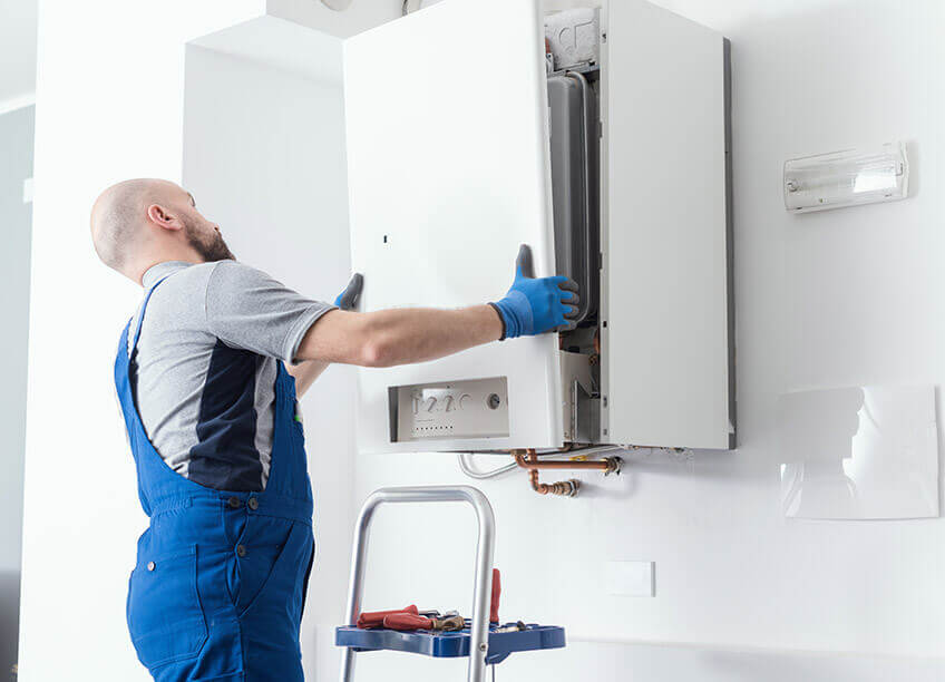 An experienced technician is performing a boiler repair service to ensure efficient heating and cooling systems in the home. The technician works on the complex boiler system, addressing issues that may affect the furnace and HVAC performance. The maintenance is part of a 24/7 service aimed at prolonging the lifespan of HVAC units, ensuring optimal comfort year-round. This expert-level repair addresses potential malfunctions in boilers and provides solutions for those seeking efficient furnace replacement or HVAC repair services.