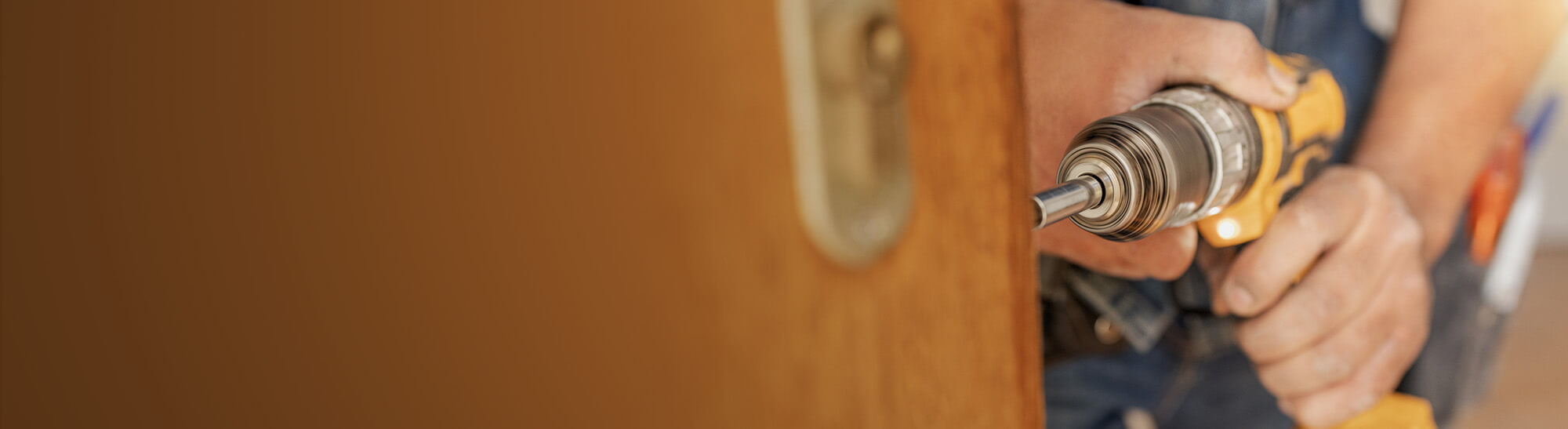 An electrician using a drill to work on a door, representing the hands-on work involved in home maintenance. This image highlights the intersection of electrical and HVAC services, including HVAC repair, installation, and furnace replacement. The drilling process exemplifies the skilled work required for installations, repairs, and ensuring optimal functioning of HVAC systems, which play a crucial role in maintaining the comfort and efficiency of residential spaces.